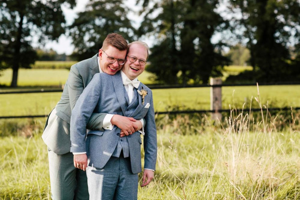 Lachendes männliches Hochzeitspaar auf Feld in Gronau